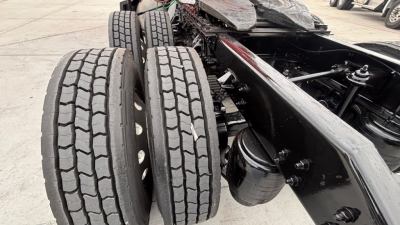 Kenworth T680 chassis view showing dual rear axles with tires and frame rails; emphasis on wheel hubs and suspension components.