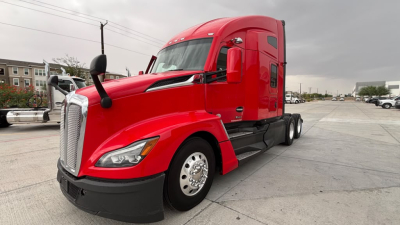 Kenworth T680 truck in red cab, front-left view showing aerodynamic hood and chrome grille with dual headlights.