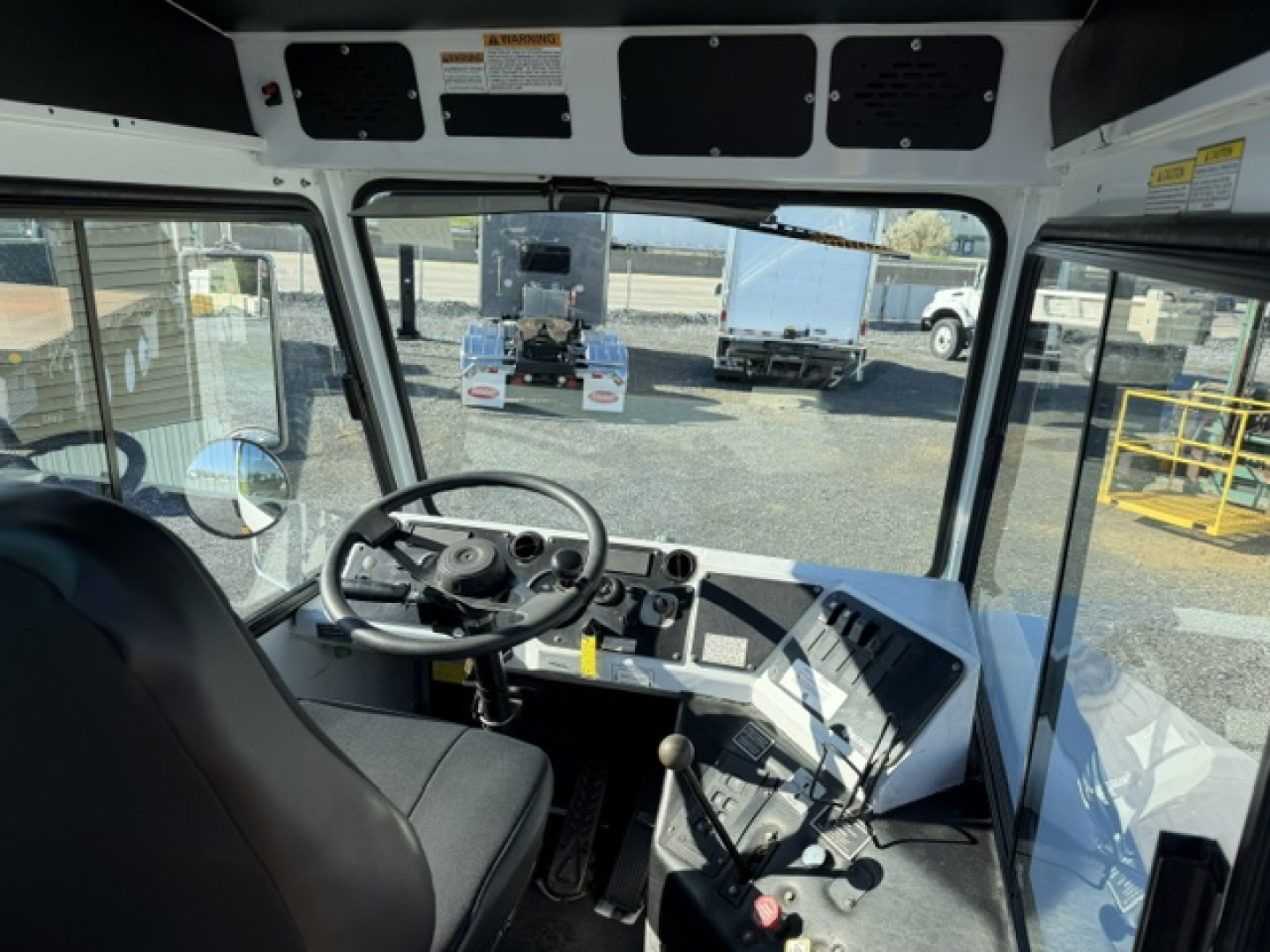 Dashboard and steering wheel view inside a cab of a capacity Sabre DOT truck showing a basic instrument cluster and controls.