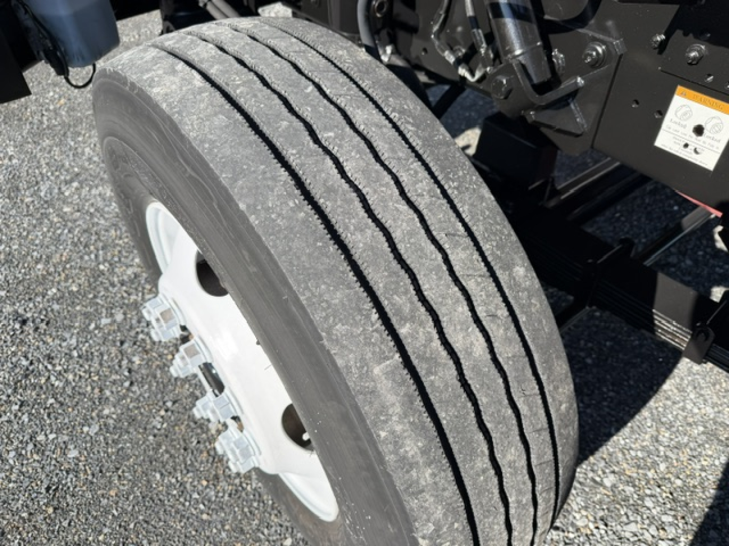Truck wheel and suspension area with tire tread and part of chassis visible.