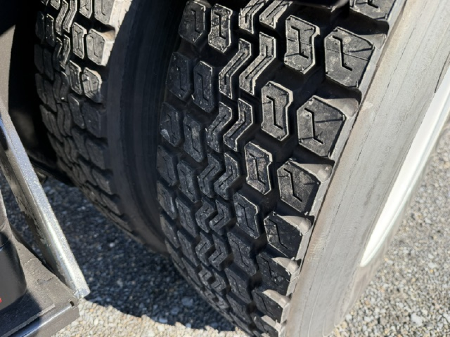 Tire tread close-up on a heavy truck dual rear wheel showing rugged lug pattern.