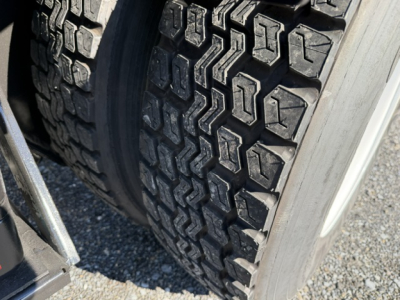 Tire tread close-up on a heavy truck dual rear wheel showing rugged lug pattern.