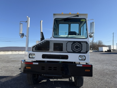 Truck cab front view with white body and black grille showing large hex logo, DOT capacity Sabre style.