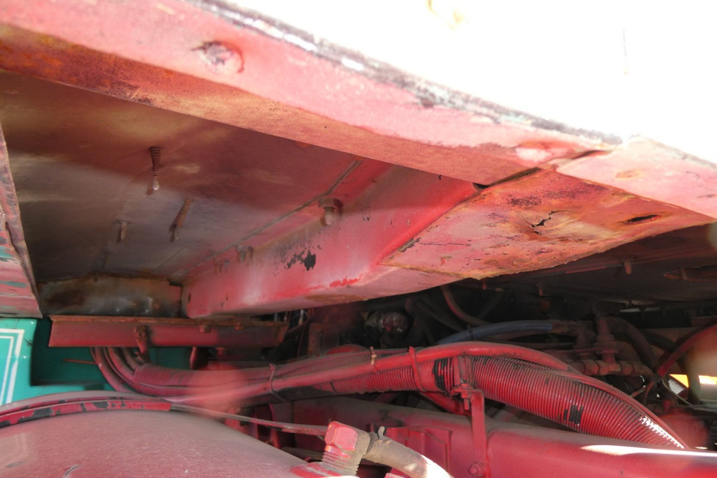 Under-hood view of a truck engine bay showing red wiring harnesses and components