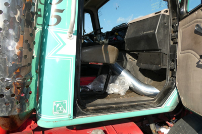 Truck cab entry showing interior of International 8100 with mint green paint and chrome exhaust, door open.