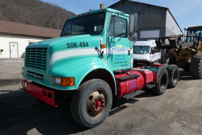 International 8100 conventional daycab truck in teal with 50K-494 on hood, stock 0314251 VIN 1HSHCAHR8VH474104, side company logo, attached equipment at rear