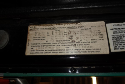 Label with manufacturer information on International 8100 truck showing tire and door data, including NAVISTAR INTERNATIONAL TRANSPORTATION CORP. and date 1997.