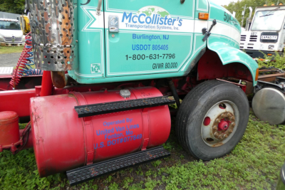 Truck side showing McCollister's Transportation Systems, Inc. with turquoise cab, red fuel tank, and wheel, part of International 8100 daycab