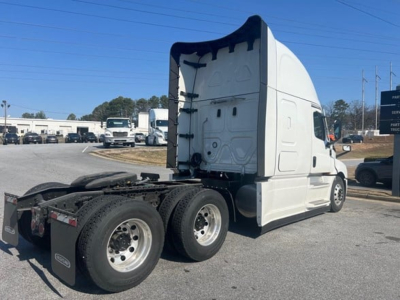 Freightliner Cascadia 126 tractor showing rear wheel tags and sleeper cab from side angle.