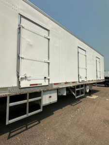 Refrigerated trailer side showing loading doors and access stairs for a 2006 utility reefer.