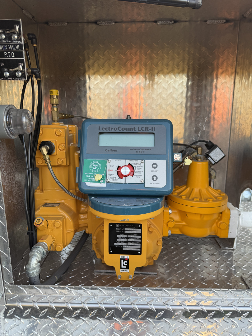 Industrial pump system with LCR-II controller mounted on yellow gearbox, labeled LectroCount LCR-II and various control knobs, wiring, and a yellow valve on a diamond-plate surface.