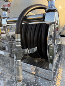 Mack MD7 component view showing a coiled hose reel and metal mounting frame with fittings.