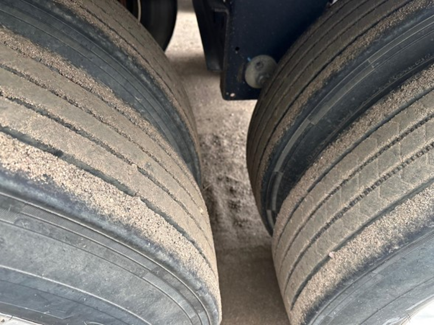 Tandem rear wheels of a 2024 Timpte Super Hopper trailer showing dirt on dual tires.