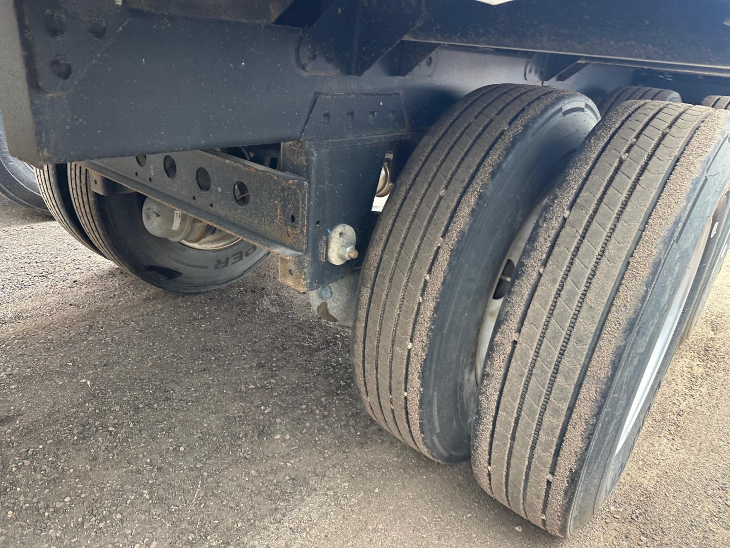 Hopper trailer dual rear axle wheels showing unbraked or non-rotating tires and undercarriage frame in view.