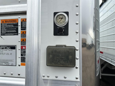Timpte Super Hopper trailer side showing pressure gauge and control panel with warning labels and data plate.