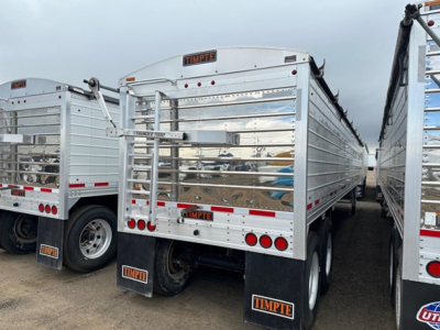 Timpte Super Hopper trailer rear view showing metal side panels, lights, reflectors, and Timpte branding on the mud flaps and tailgate.
