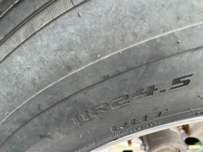 Trailer tire with sidewall markings showing '11R24.5' and 'CH' portions of the tire codes visible.
