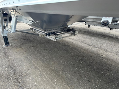 Hopper trailer undercarriage and hitch from side view, showing Timpte Super Hopper features and trailer support structures.