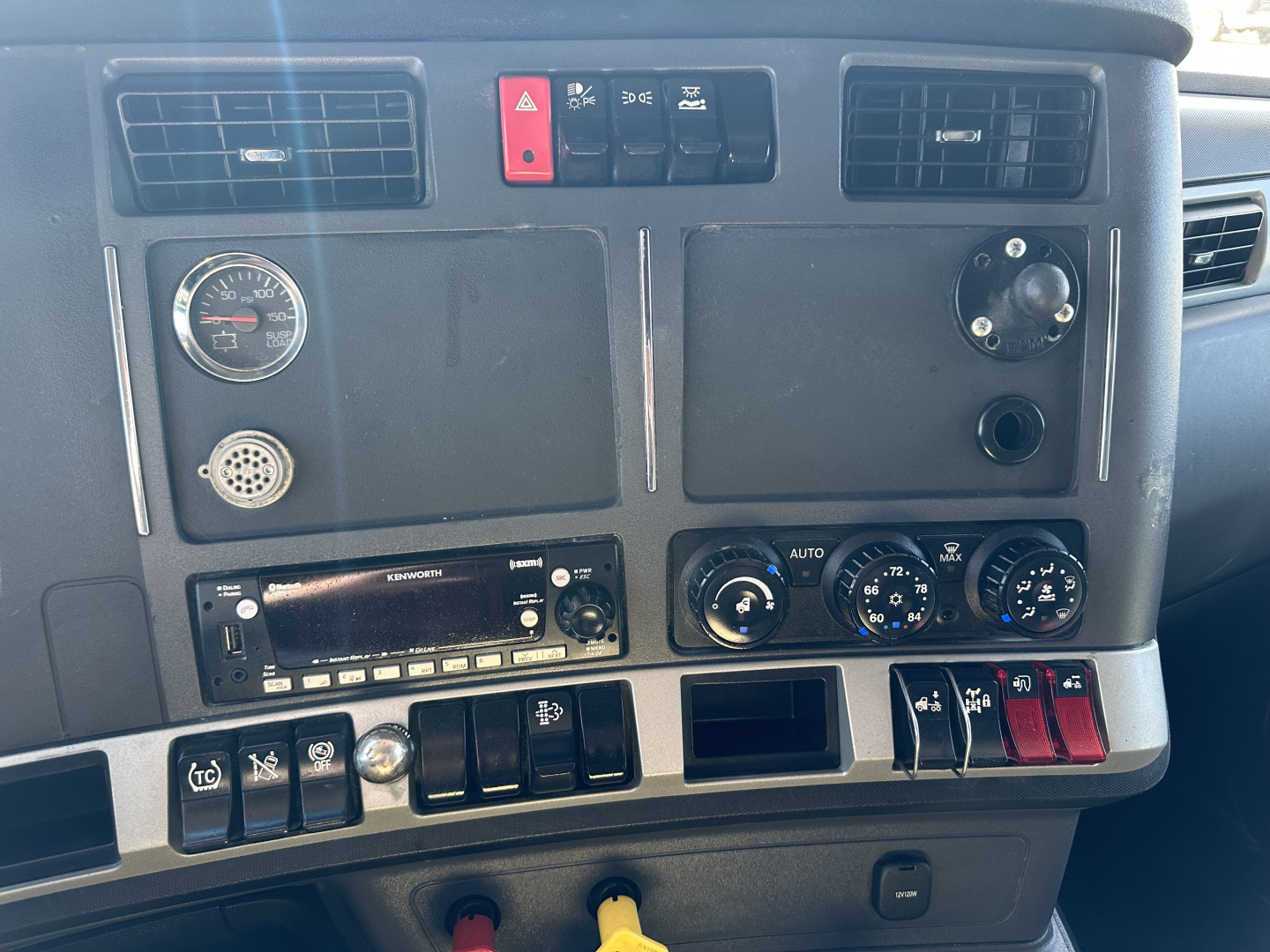 Dashboard view of a 2022 Kenworth T680 truck showing instrument panel, air vents, control switches, and radios. Text visible: none legible beyond standard gauges and knobs.