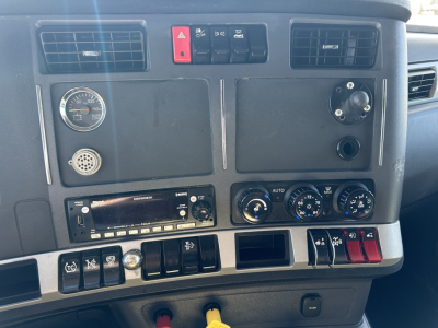 Dashboard view of a 2022 Kenworth T680 truck showing instrument panel, air vents, control switches, and radios. Text visible: none legible beyond standard gauges and knobs.