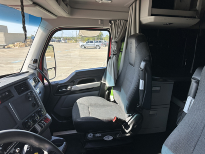 Kenworth T680 interior cab view showing driver seat and dashboard; window view outside.