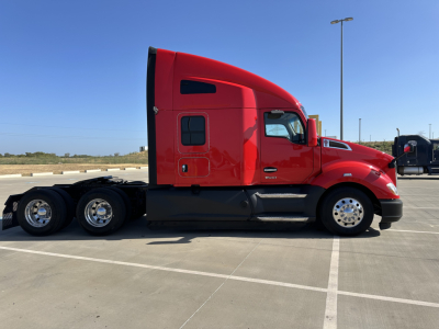 Kenworth T680 tractor in red, side view showing sleeper cab and triple rear axle, no visible text on image.