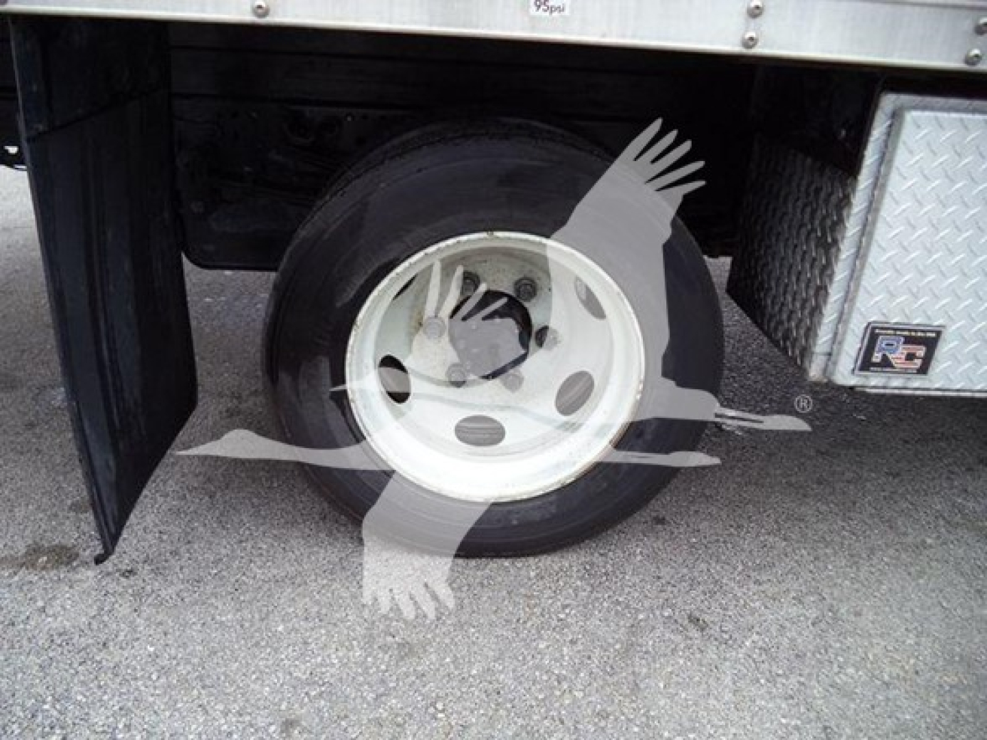 Isuzu NQR wheel and undercarriage view showing front wheel and fender area of a box truck.