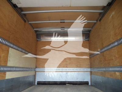 Isuzu NQR truck box interior showing wooden walls and metal E-track rails, empty cargo area with rear door tracks visible.
