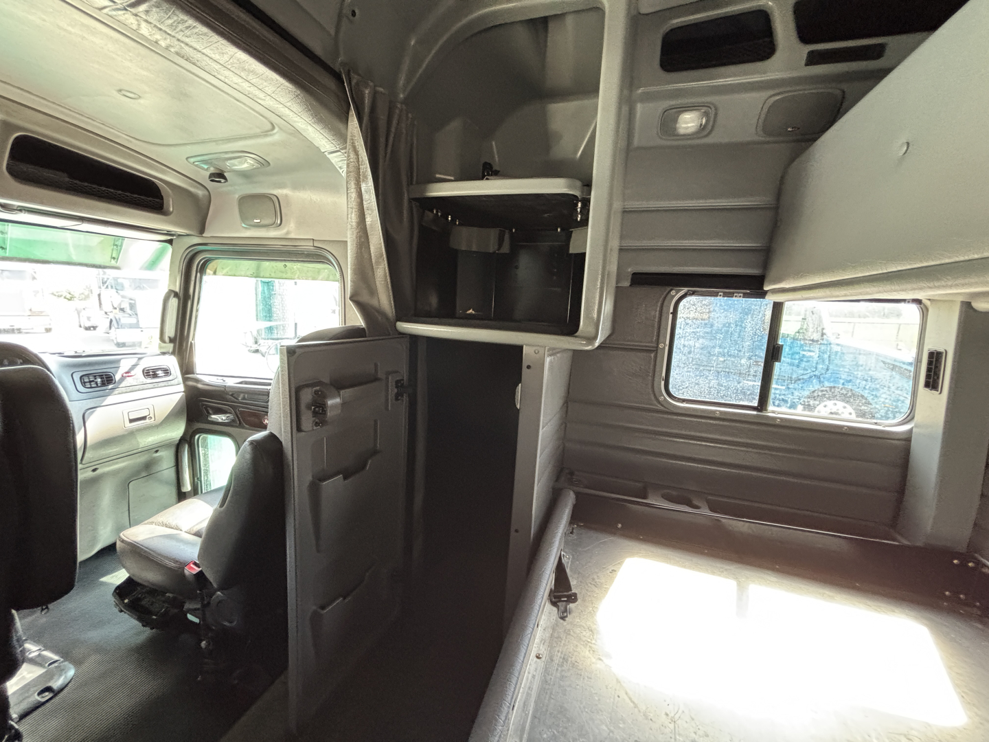 Peterbilt 389 truck cab interior view showing sleeper area and storage cabinets.