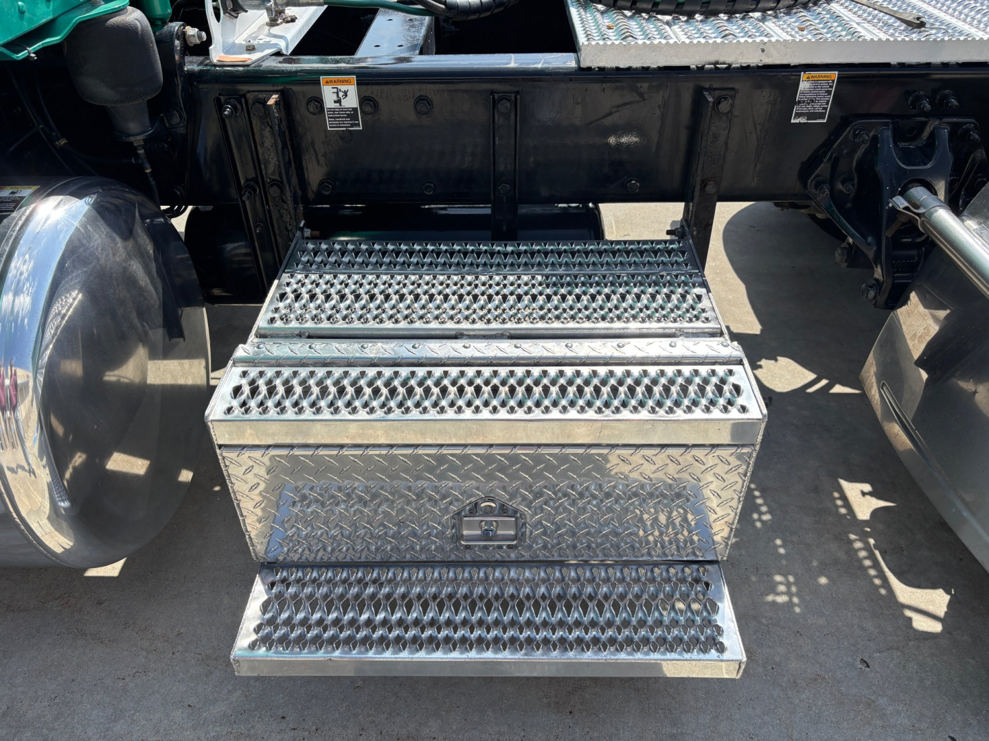 Peterbilt 389 truck rear with diamond plate steps and storage box under the cab.