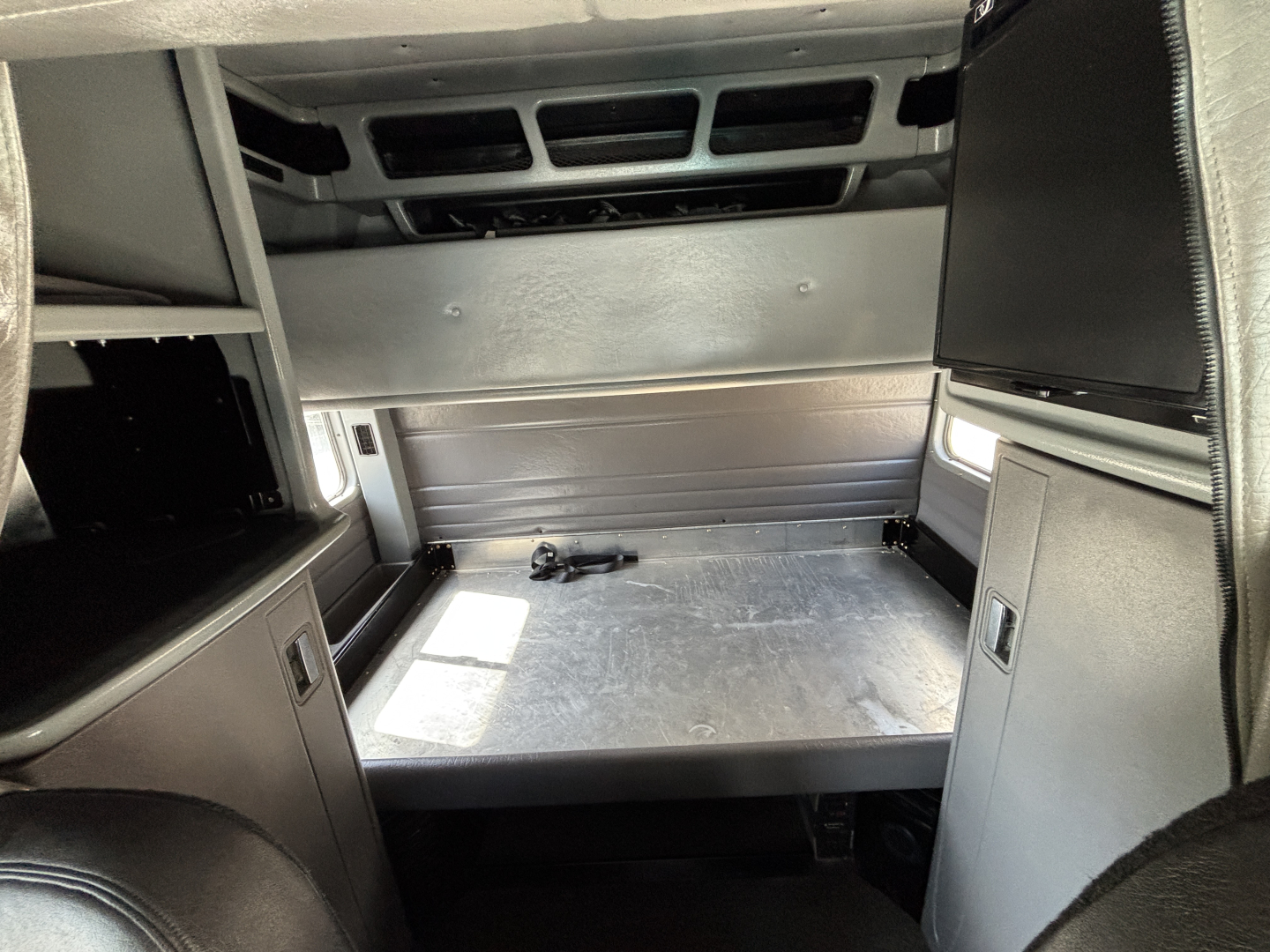 Peterbilt 389 sleeper cab interior cargo area with metal bed platform and side panels.