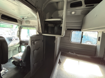 Peterbilt 389 truck cab interior view showing sleeper area and storage cabinets.
