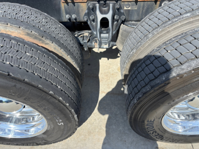 Dual rear dual wheels of a Peterbilt truck showing tires and suspension components.