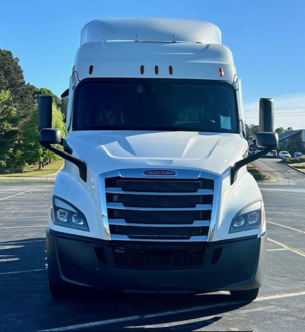 Freightliner Cascadia 116 front view showing large black grille, elevated sleeper cab, and Mercedes-style headlights.