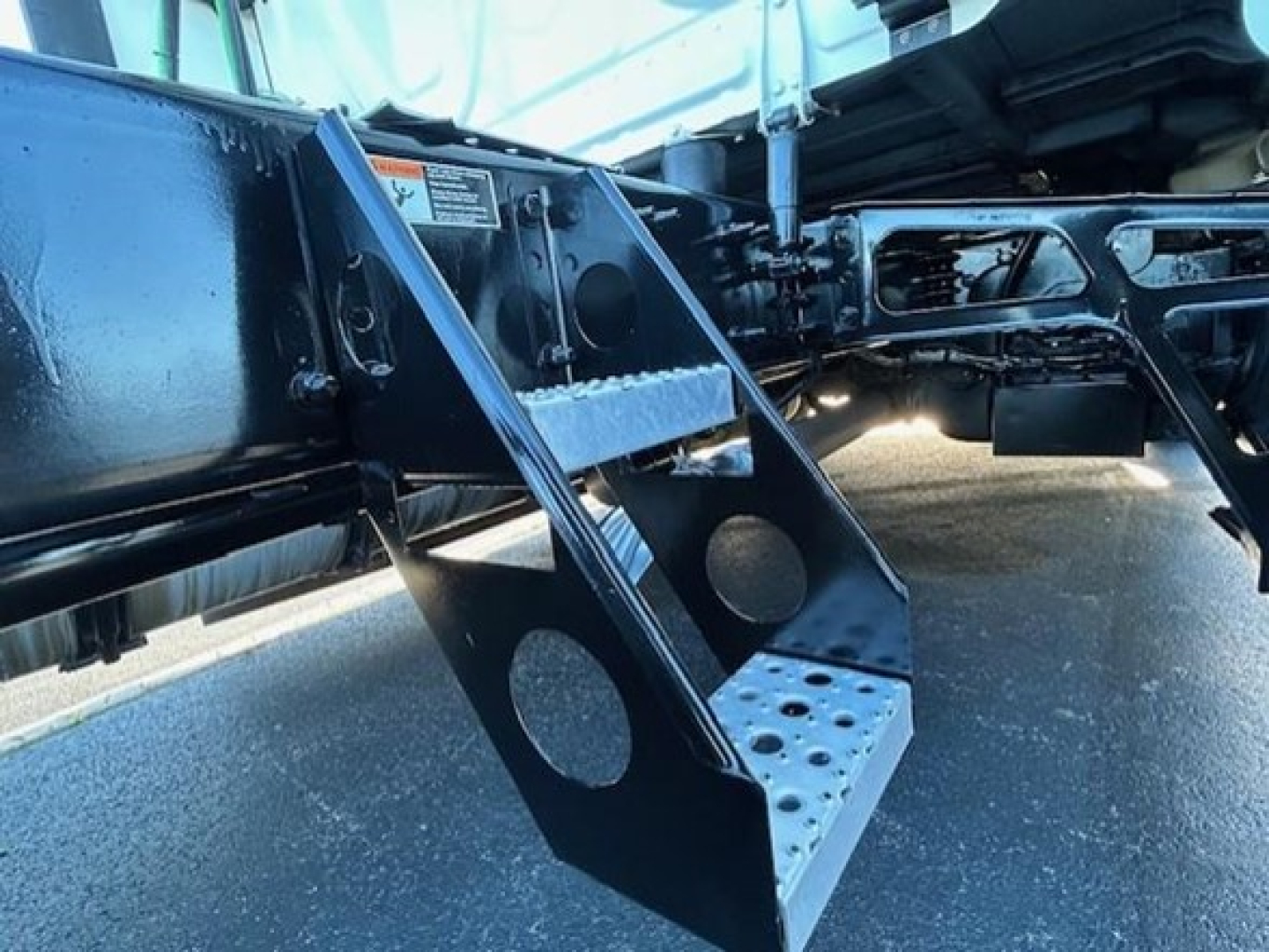 Freightliner Cascadia chassis with fold-out steps and undercarriage components visible.