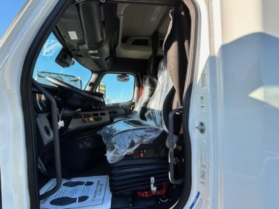 Freightliner Cascadia 116 truck cab interior view showing steering wheel, dashboard, and wrapped driver's seat, inside a sleeper cab.