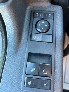 Freightliner Cascadia 116 door panel controls showing window switches and mirror adjustment knob.