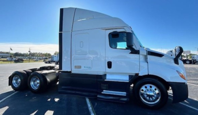Truck side profile showing Freightliner Cascadia cab with sleeper, chrome wheels, and dual rear axles.