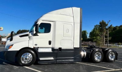 Freightliner Cascadia 116 conventional sleeper truck showing side view with white cab and dual rear axles, chrome wheels.