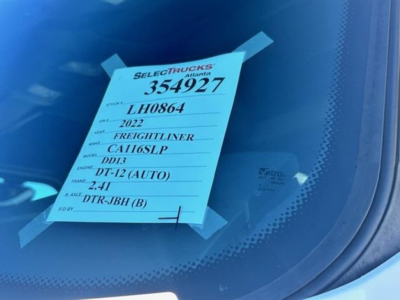 Vehicle tag taped to Freightliner Cascadia windshield showing stock 354927, year 2022, model CA116LP, engine D13 (DT-12 auto), VIN 3AKJHPDV6NSLH0864, DT-12 (AUTO), 2.41 rear axle, fuel type unspecified.