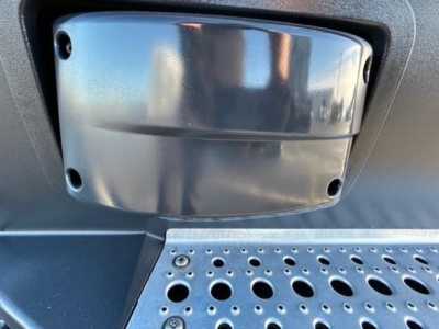 Freightliner Cascadia engine bay area showing chrome glove-like air intake cover and perforated metal step platform.