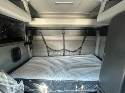 Freightliner Cascadia truck sleeper bunk area with bed and storage nets visible