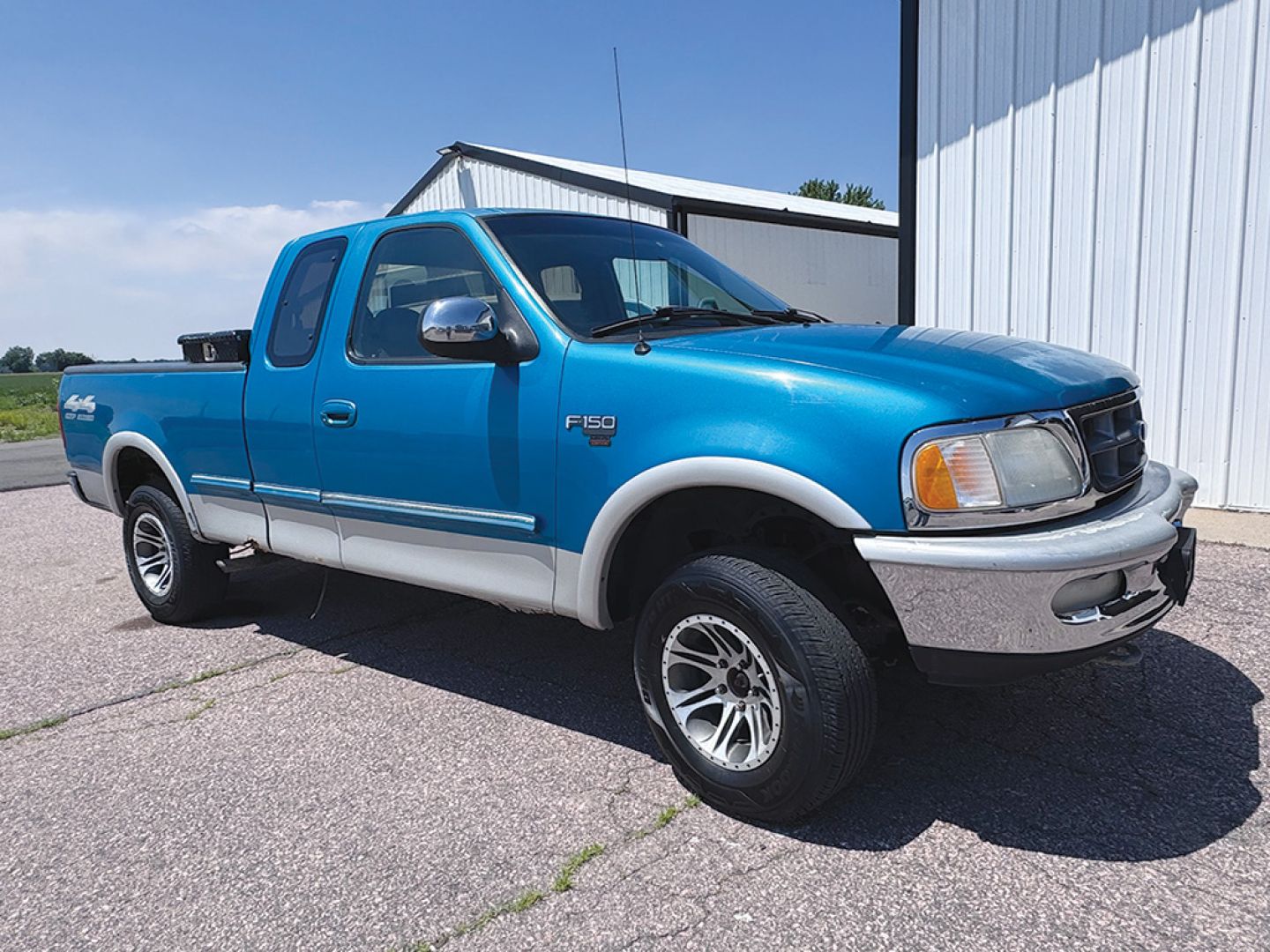 Ford F-150 pickup truck in blue, front-right view, with extended cab and chrome bumper.