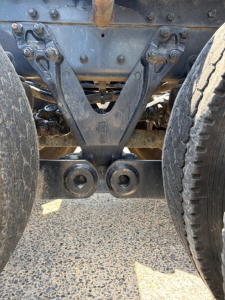 Kenworth T880 chassis underside showing rear suspension components and dual axles.