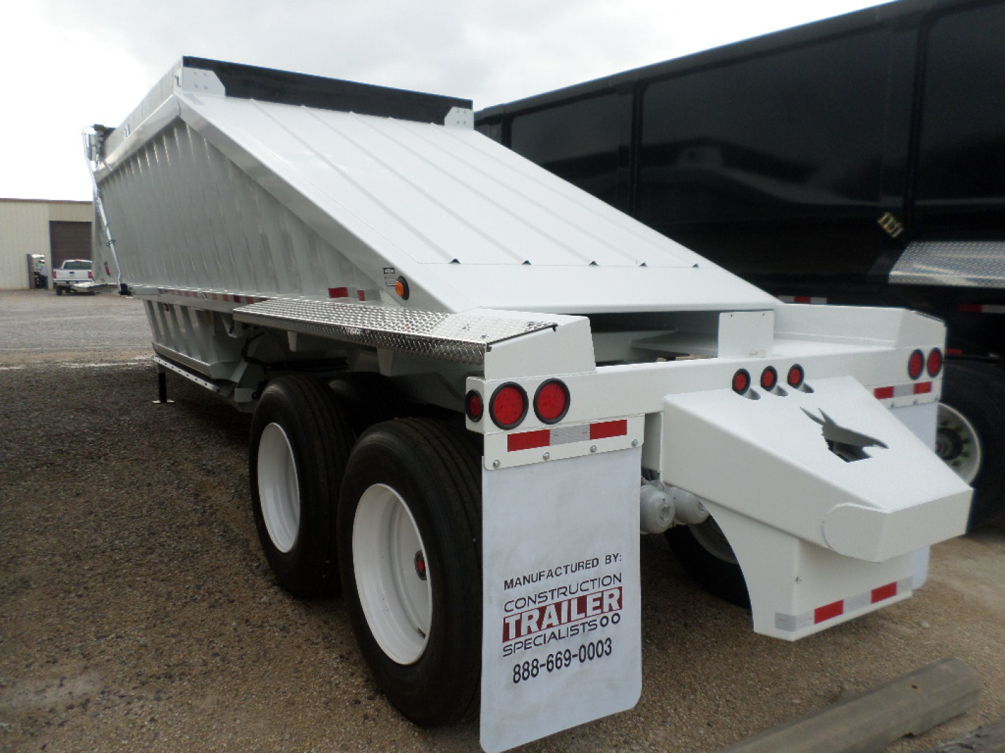 Trailer rear and side view showing white air-ride dump trailer with dual axles and CCC branding plate.