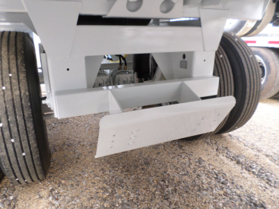Trailer hitch underside showing air ride suspension and leaf springs with white frame and dual rear wheels.