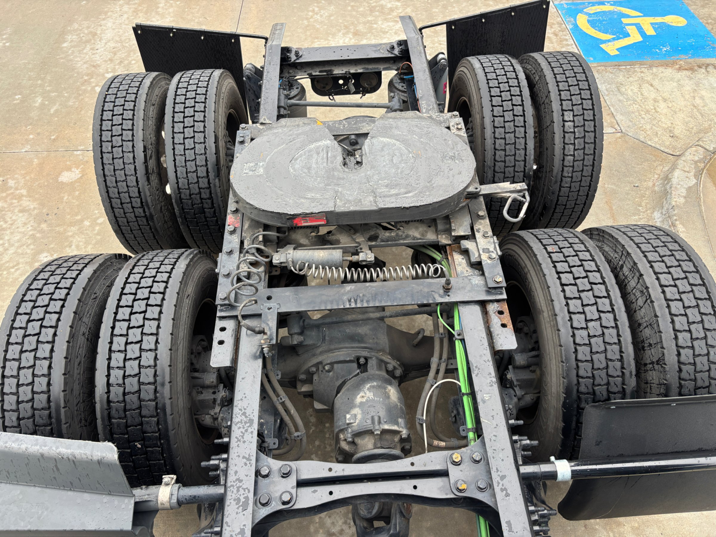 Conventional sleeper truck chassis showing rear axles and drivetrain with twin dual rear tandems and suspension components.