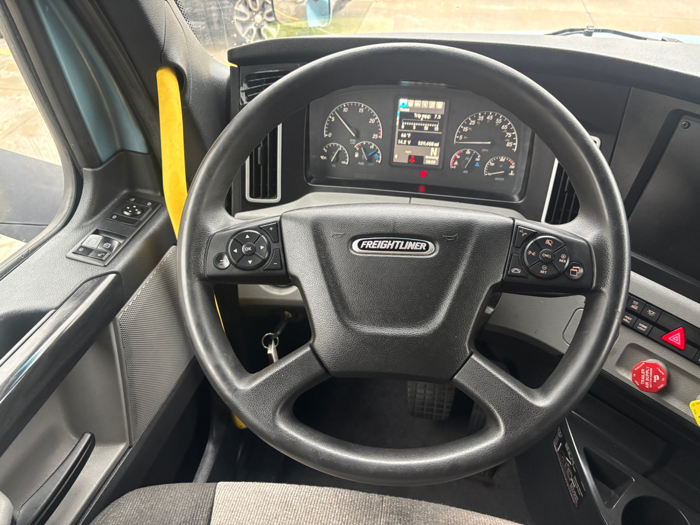 Steering wheel and dashboard of a Freightliner PT126064ST truck cab interior showing instrument cluster and steering column.