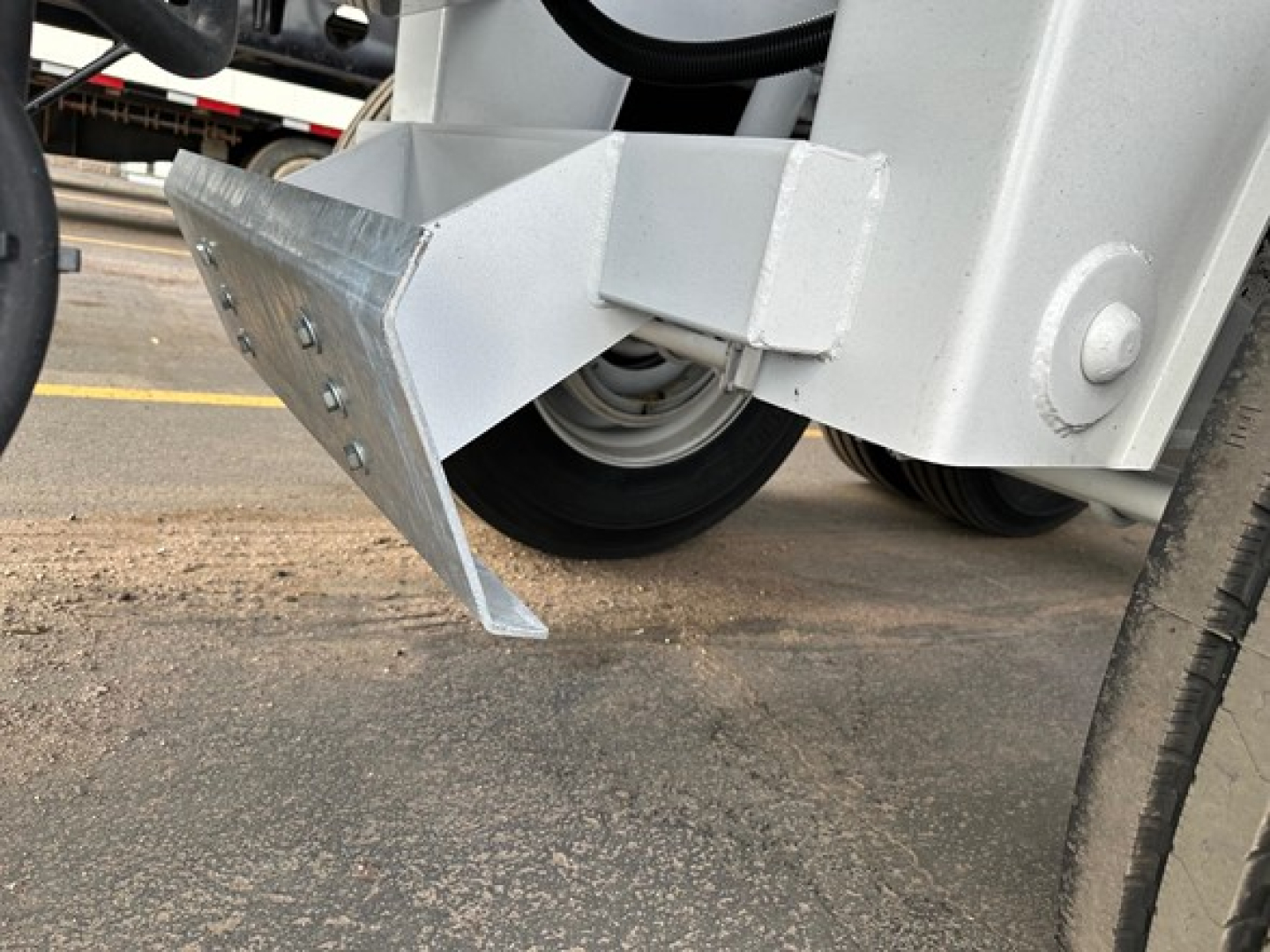 Bottom dump trailer hitch area with a metal mounting bracket and wheel visible.