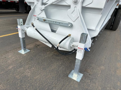 Bottom dump trailer leg and hydraulic hose assembly with support legs and frame stabilizers visible.